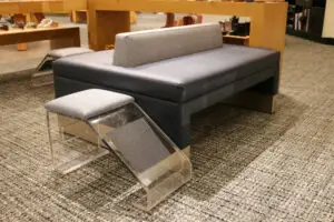 A couch with two pillows and a bench on top of it.