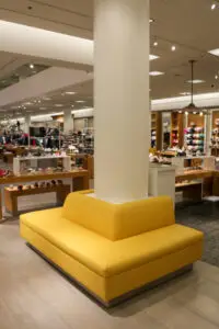 A yellow couch in the middle of a store.